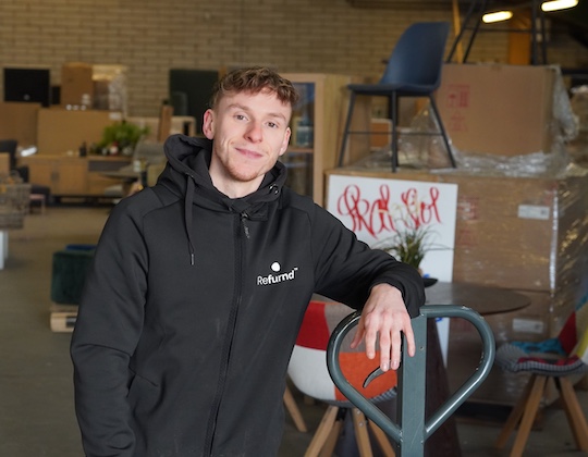 Marc Dyberg fra Refurnd møbelbutik i Them nær Silkeborg står med en palleløfter på et møbellager.